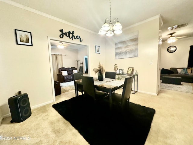 carpeted dining area featuring ceiling fan with notable chandelier and ornamental molding