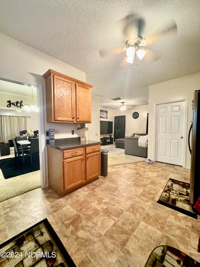 kitchen with a textured ceiling, ceiling fan, and stainless steel refrigerator