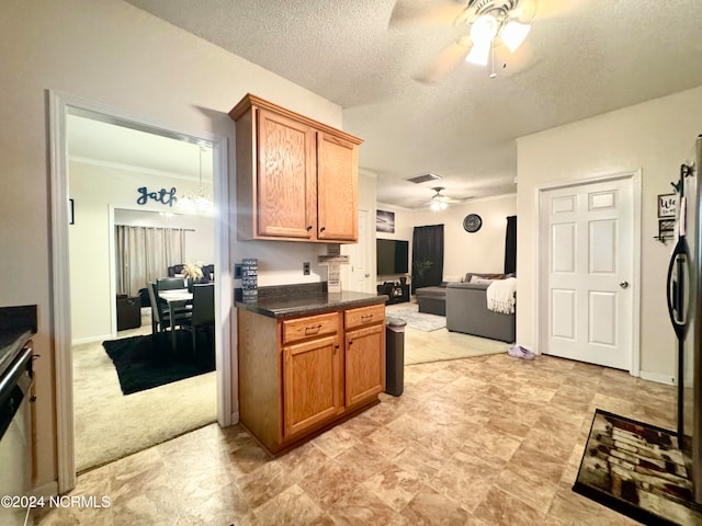 kitchen with a textured ceiling, ceiling fan, and light colored carpet