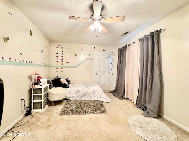 carpeted bedroom featuring a textured ceiling and ceiling fan