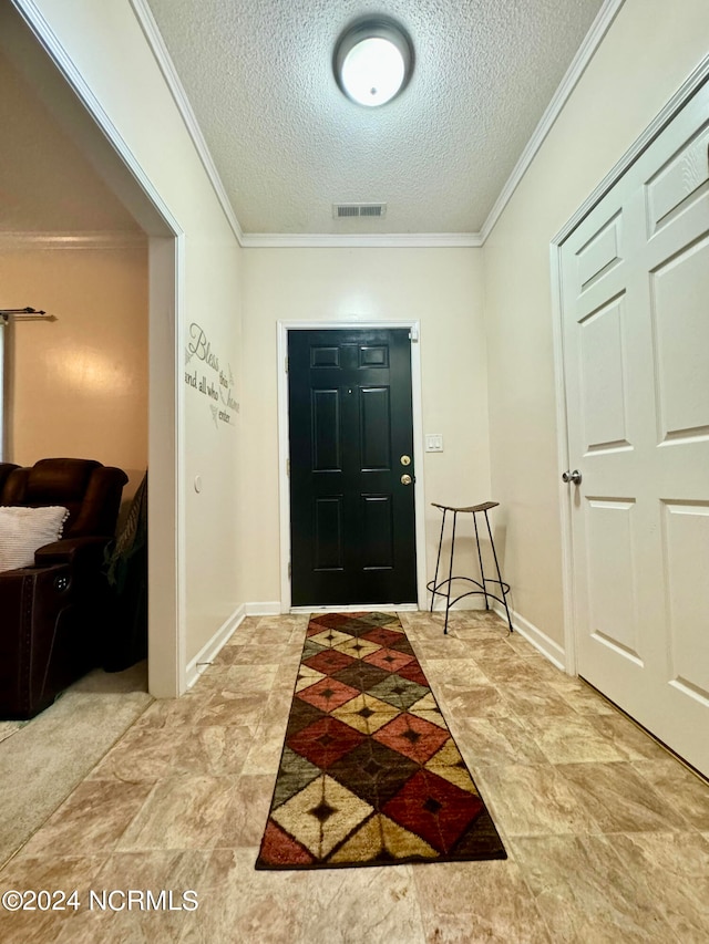 foyer entrance featuring a textured ceiling and crown molding