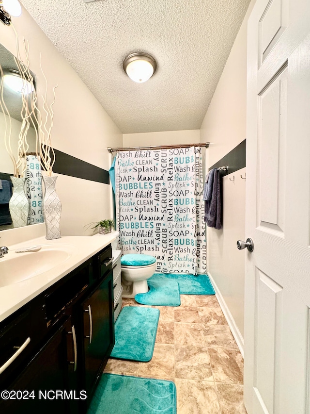 bathroom with a shower with curtain, a textured ceiling, vanity, and toilet