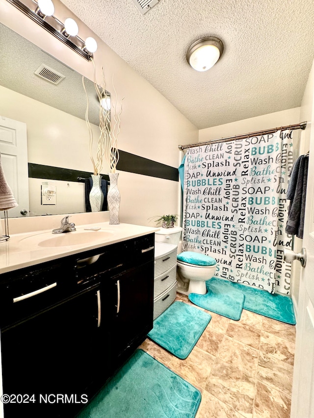 bathroom with vanity, toilet, a textured ceiling, and curtained shower