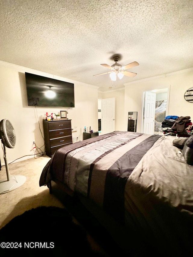 carpeted bedroom featuring a textured ceiling, ornamental molding, and ceiling fan