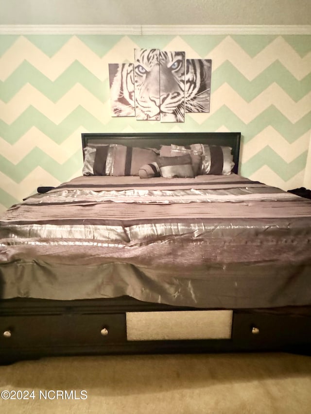 bedroom with ornamental molding and light colored carpet