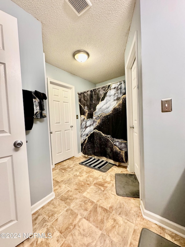 bathroom featuring a textured ceiling and walk in shower