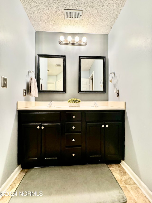 bathroom featuring tile patterned flooring, a textured ceiling, and vanity