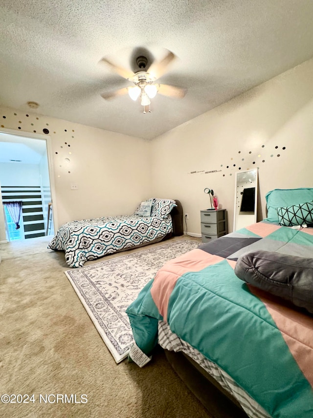 bedroom featuring carpet, ceiling fan, access to outside, and a textured ceiling