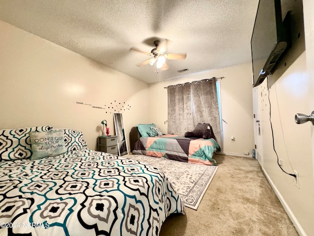 carpeted bedroom featuring a textured ceiling and ceiling fan