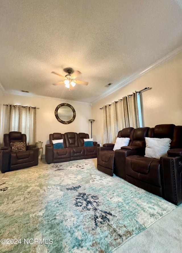 carpeted living room featuring a textured ceiling, ornamental molding, and ceiling fan