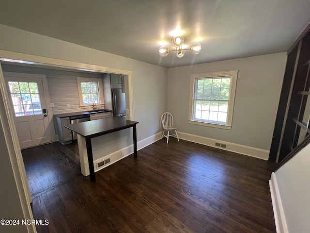 kitchen featuring stainless steel appliances, a wealth of natural light, dark wood-style flooring, dark countertops, and visible vents
