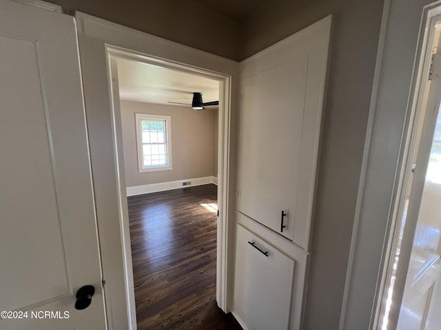 corridor with baseboards and dark wood-style flooring