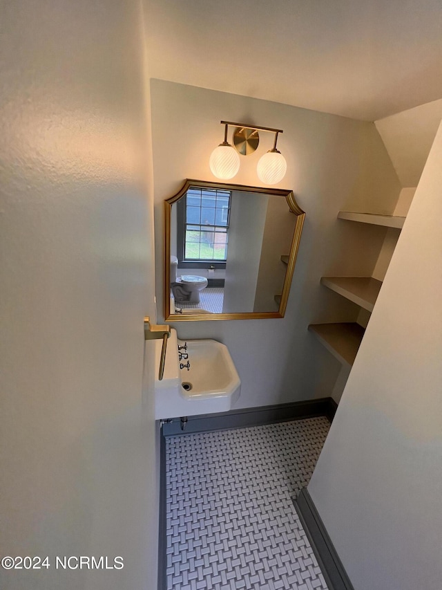 bathroom with baseboards, tile patterned floors, and a sink