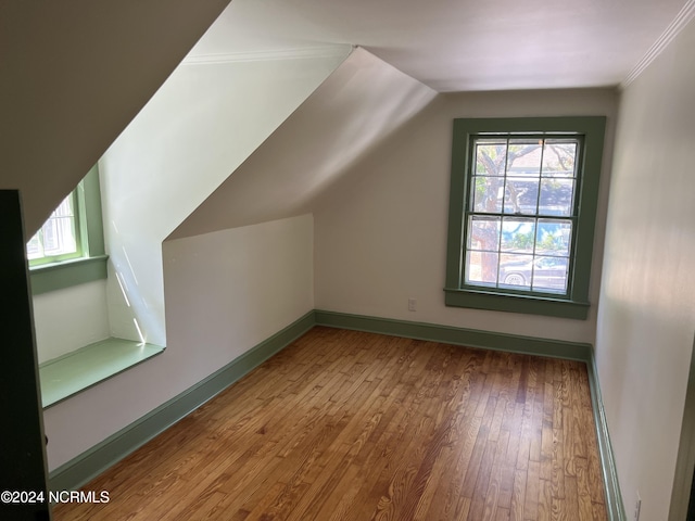 additional living space with vaulted ceiling and hardwood / wood-style flooring