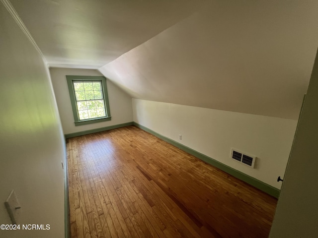 additional living space featuring wood-type flooring and lofted ceiling