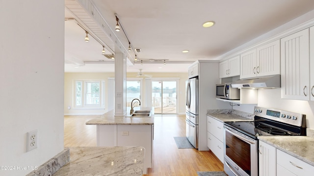 kitchen featuring appliances with stainless steel finishes, light wood-type flooring, light stone counters, sink, and white cabinets