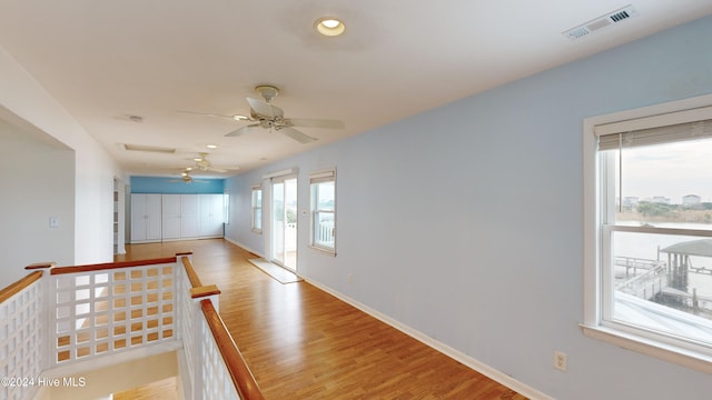 hall with plenty of natural light and light hardwood / wood-style flooring