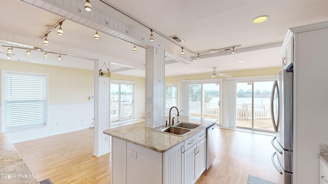 kitchen with light hardwood / wood-style floors, white cabinetry, sink, and stainless steel appliances