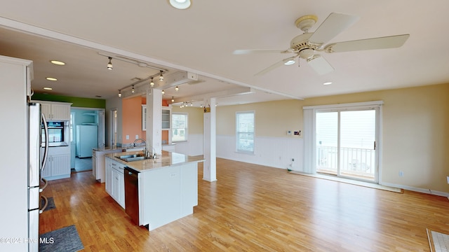 kitchen with a kitchen island with sink, white cabinets, sink, ceiling fan, and light wood-type flooring