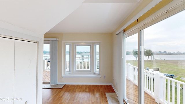 unfurnished sunroom featuring a water view