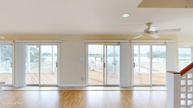 interior space with ceiling fan, light hardwood / wood-style floors, and a water view