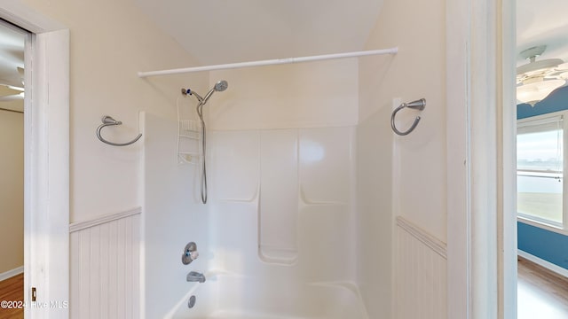 bathroom featuring wood-type flooring and washtub / shower combination