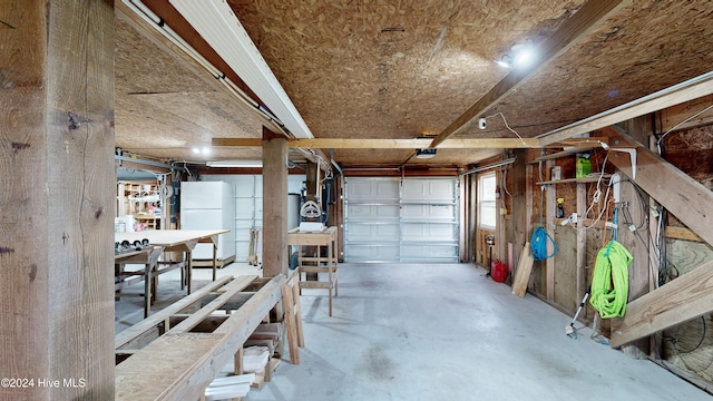 garage featuring white refrigerator and a garage door opener