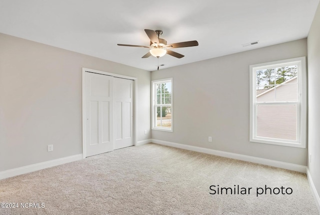 unfurnished bedroom with a closet, ceiling fan, and carpet floors