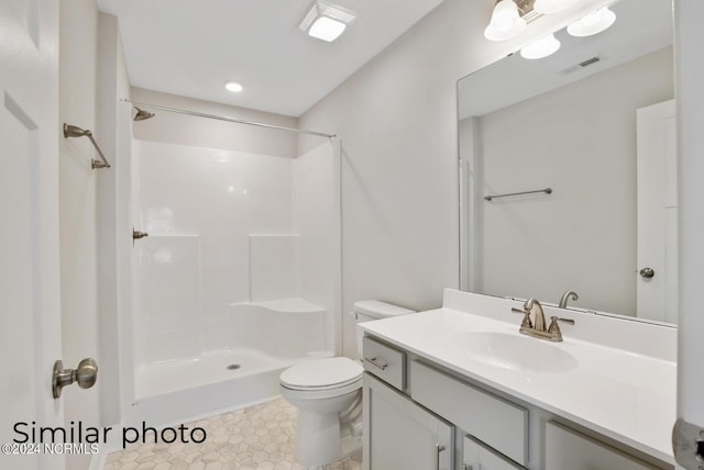 bathroom featuring toilet, walk in shower, and vanity