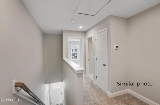 hallway featuring light colored carpet