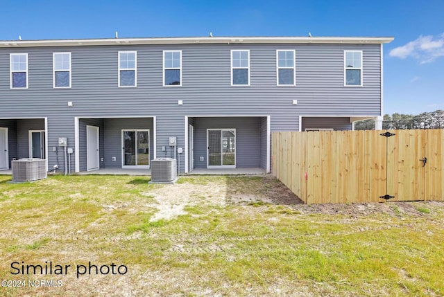 back of property with a lawn, a patio area, and central AC unit