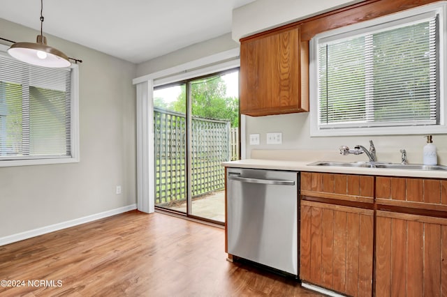 kitchen featuring light hardwood / wood-style flooring, dishwasher, decorative light fixtures, and sink