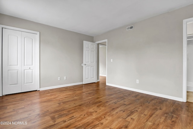 unfurnished bedroom with a closet and hardwood / wood-style floors