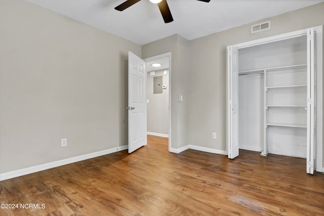 unfurnished bedroom featuring ceiling fan, a closet, and wood-type flooring