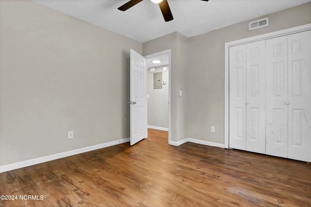 unfurnished bedroom with wood-type flooring, ceiling fan, and a closet