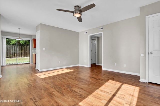 empty room with ceiling fan and hardwood / wood-style flooring