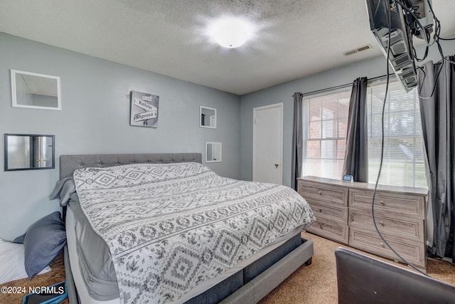 bedroom with light carpet and a textured ceiling