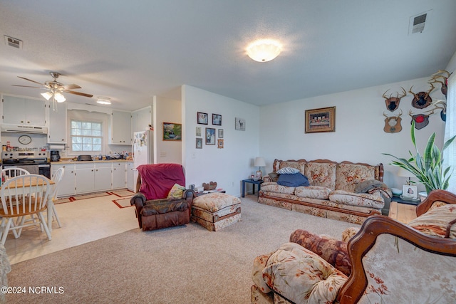 carpeted living room featuring a textured ceiling and ceiling fan