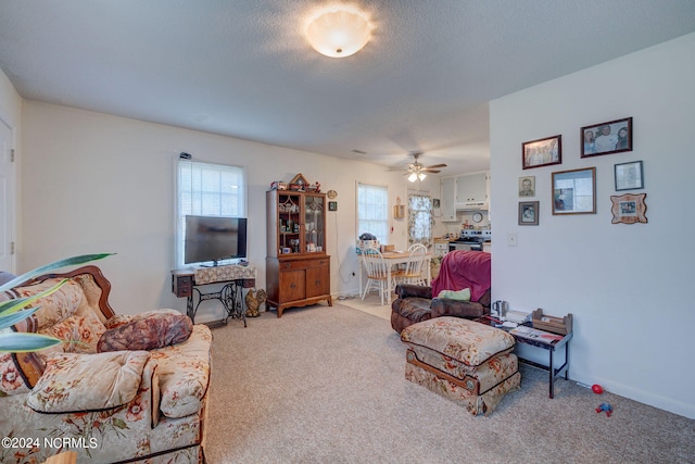 carpeted living room featuring ceiling fan and a healthy amount of sunlight