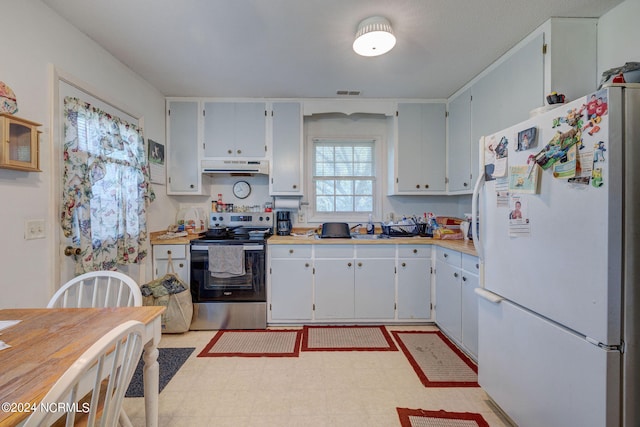 kitchen with stainless steel range with electric stovetop and white fridge