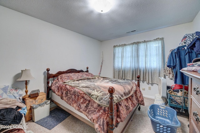 bedroom with a textured ceiling and light colored carpet