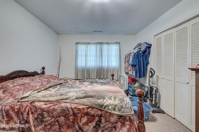 bedroom featuring a closet, a textured ceiling, and carpet flooring