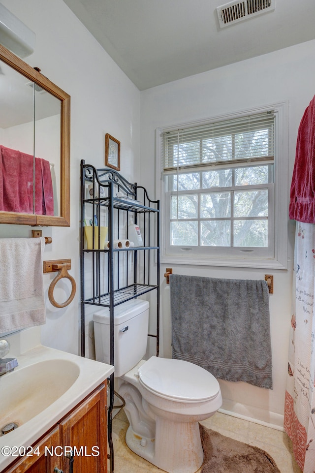 bathroom with vanity, plenty of natural light, toilet, and tile patterned floors