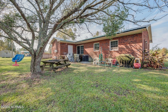 rear view of house with a yard and central air condition unit