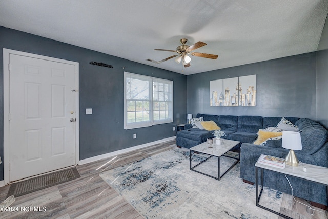 living room with ceiling fan, hardwood / wood-style floors, and a textured ceiling