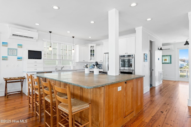 6615 W Beach Dr, Oak Island, NC 28465 - kitchen with appliances with stainless steel finishes, a large island, a sink, wood finished floors, and recessed lighting