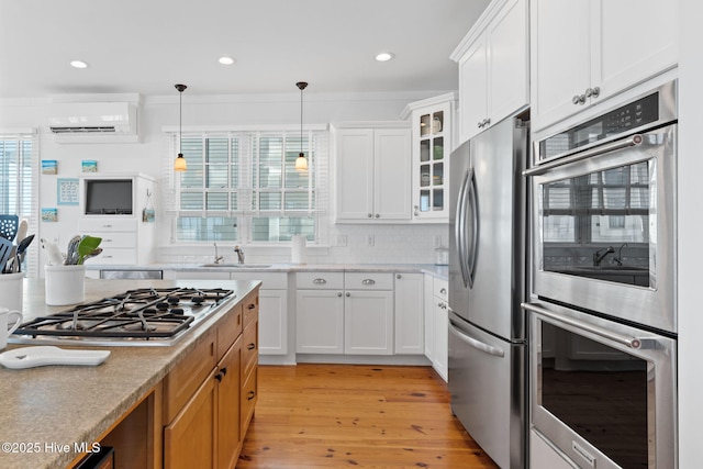 6615 W Beach Dr, Oak Island, NC 28465 - kitchen with appliances with stainless steel finishes, a sink, light wood-type flooring, glass insert cabinets, and light countertops