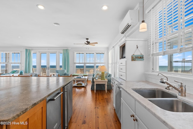 6615 W Beach Dr, Oak Island, NC 28465 - kitchen featuring open floor plan, a wall mounted air conditioner, a sink, a ceiling fan, and recessed lighting