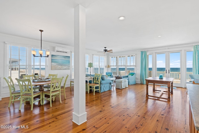 6615 W Beach Dr, Oak Island, NC 28465 - dining room featuring an AC wall unit, ceiling fan, wood-type flooring, a chandelier, and recessed lighting