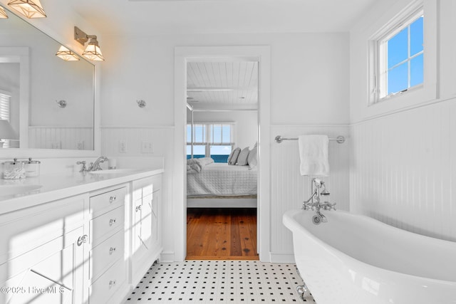 6615 W Beach Dr, Oak Island, NC 28465 - ensuite bathroom featuring wainscoting, a freestanding tub, and double vanity